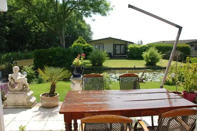 a wooden table and chairs in a garden at Villa Pantano in Berkhout