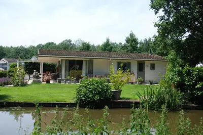 a house with a pond in front of it at Villa Pantano in Berkhout