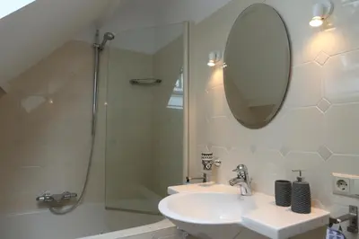 a bathroom with a sink and a shower and a mirror at Sunny Guesthouse in Bergen