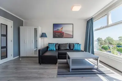 a living room with a couch and a table at Blue Shell With Private Parking Garage in Zandvoort