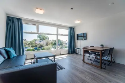a living room with a couch and a dining room table at Blue Shell With Private Parking Garage in Zandvoort