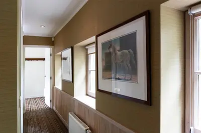 a hallway with a painting of a horse on the wall at Bosvilla Kennemerduinen in IJmuiden