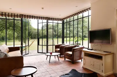 a living room with a tv and some chairs at Bosvilla Kennemerduinen in IJmuiden