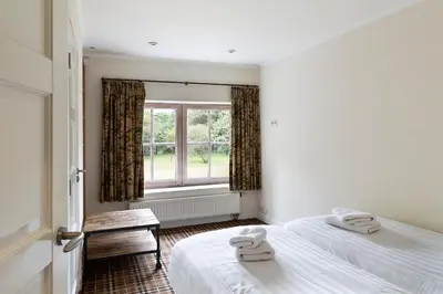 two beds in a room with a window at Bosvilla Kennemerduinen in IJmuiden