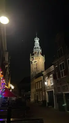 a tall building with a clock tower at night at Luxury Chalets Monnickendam in Monnickendam