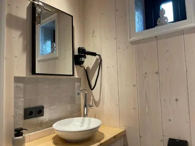 a bathroom with a white sink and a mirror at Luxury Chalets Monnickendam in Monnickendam