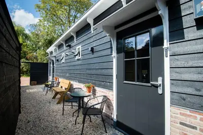 a patio with chairs and a table next to a building at Luxury Chalets Monnickendam in Monnickendam