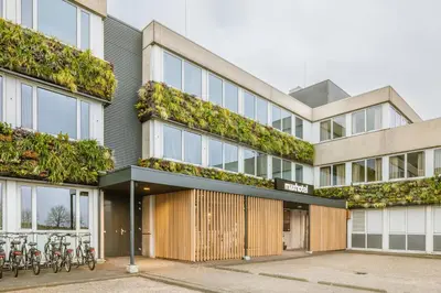 an apartment building with plants on the facade at Maxhotel Amsterdam Airport Schiphol - Recently Renovated in Hoofddorp