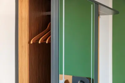 a closet with wooden doors and a green wall at Maxhotel Amsterdam Airport Schiphol - Recently Renovated in Hoofddorp