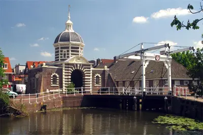 a building with a clock tower next to a body of water at ZeeBedStay in Noordwijk aan Zee