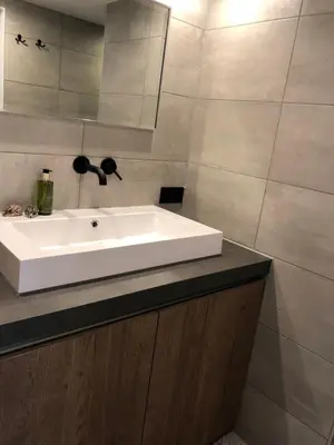 a bathroom with a white sink on a counter at Bergenshofje in Bergen