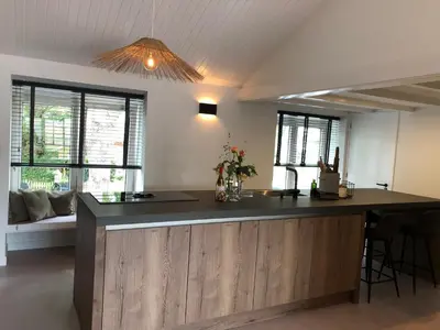 a kitchen with a island in a room with windows at Bergenshofje in Bergen