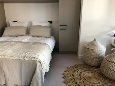 a bedroom with a bed with white sheets and pillows at Bergenshofje in Bergen