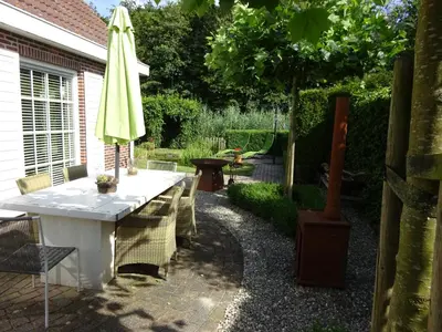 a patio with a table and an umbrella at Holiday Home Zeewolde in Zeewolde