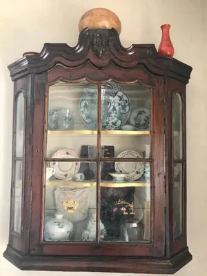 a china cabinet with plates and bowls in it at De Sloep in Bergen