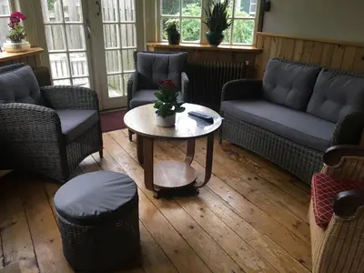 a living room with couches and a table and chairs at De Sloep in Bergen