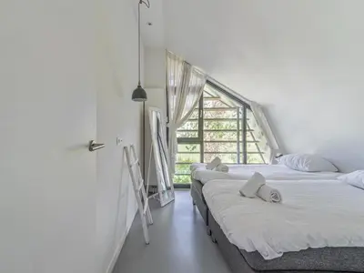 two beds in a room with a window at Beautiful Holiday home near the sea in Egmond aan den Hoef