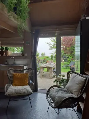a living room with two chairs and a patio at Tuinhuis in Lutjewinkel