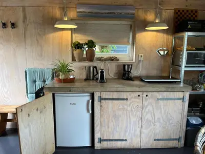 a kitchen with a counter and a refrigerator at Tuinhuis in Lutjewinkel
