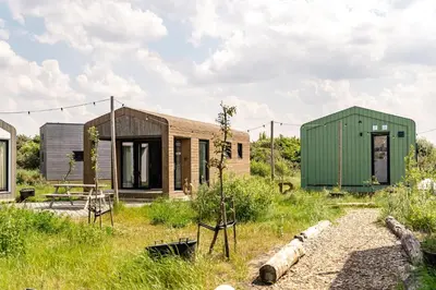 a house with a green container and a green house at Basecamp Tiny House Eco-resort IJmuiden in IJmuiden