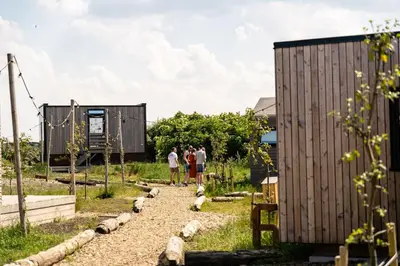 a group of people walking down a gravel path next to a building at Basecamp Tiny House Eco-resort IJmuiden in IJmuiden