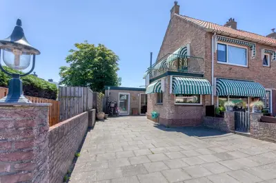 a brick house with a balcony and a brick wall at KUST Zandvoort Private Parking included in Zandvoort