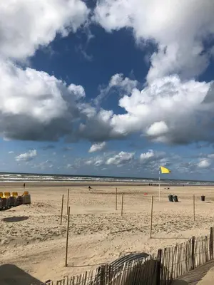 a beach with a yellow kite in the sand at KUST Zandvoort Private Parking included in Zandvoort