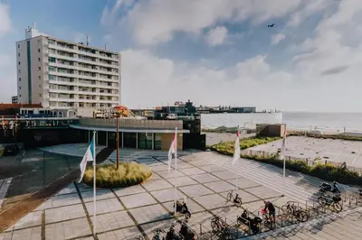 a building with bikes parked on a sidewalk near the beach at KUST Zandvoort Private Parking included in Zandvoort