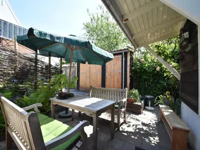 a patio with a table and a green umbrella at Serene Getaway in Edam in Edam