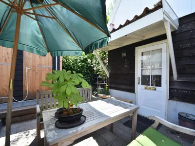 a table with a potted plant and an umbrella on a patio at Serene Getaway in Edam in Edam
