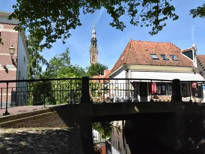 a bridge over a river with a clock tower at Serene Getaway in Edam in Edam