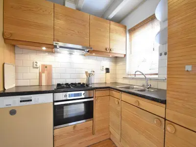 a kitchen with wooden cabinets and a stove and a sink at Serene Getaway in Edam in Edam