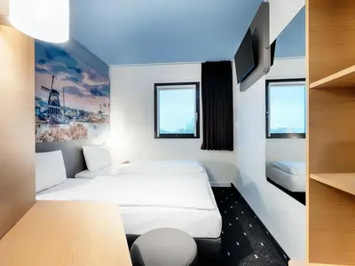 a hotel room with two beds and a tv at B&B Hotel Amsterdam-Zaandam in Zaandam