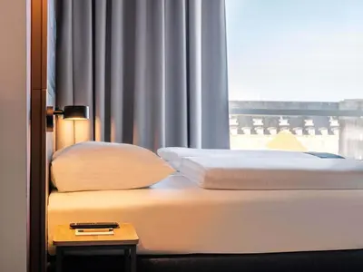 a bed in a hotel room with a window at B&B Hotel Amsterdam-Zaandam in Zaandam