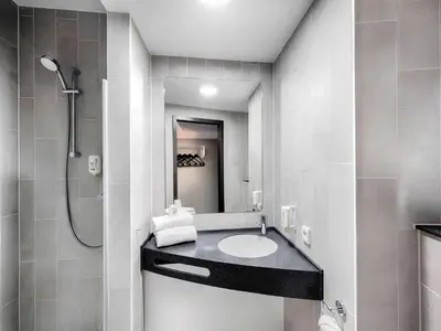 a bathroom with a sink and a shower at B&B Hotel Amsterdam-Zaandam in Zaandam