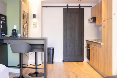 a kitchen with a bar and a door in a room at Studio 23 in Zandvoort