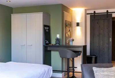a bedroom with a bed and a bar in it at Studio 23 in Zandvoort