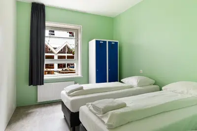 two beds in a room with green walls and a window at Hans Brinker Hostel Amsterdam in Amsterdam