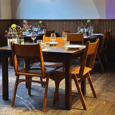 a wooden table with chairs and wine glasses at Hans Brinker Hostel Amsterdam in Amsterdam