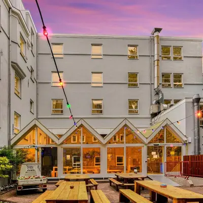 a building with picnic tables in front of it at Hans Brinker Hostel Amsterdam in Amsterdam