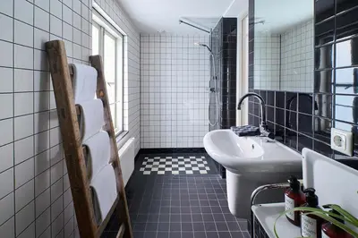 a black and white bathroom with a sink and a toilet at Hello I'm Local - Boutique Hostel in Haarlem
