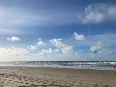 a person is flying a kite on the beach at Bijzonder Bakkum in Castricum