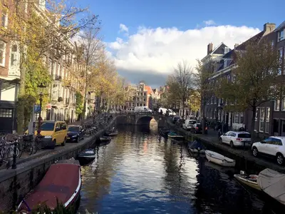 a river with boats in a city with buildings at B&B Looier in Amsterdam