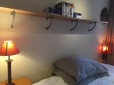 a bedroom with a bed and a shelf on the wall at B&B Looier in Amsterdam
