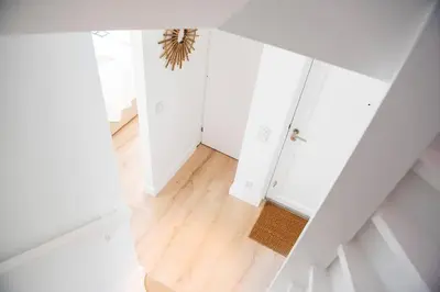an attic hallway with white walls and wood floors at Luxury villa on peaceful location. Boat optional in Vinkeveen