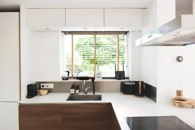 a white kitchen with a sink and a window at Luxury villa on peaceful location. Boat optional in Vinkeveen