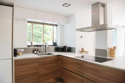 a kitchen with wooden cabinets and a sink at Luxury villa on peaceful location. Boat optional in Vinkeveen