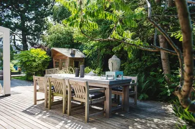 a wooden table and chairs on a wooden deck at Luxury villa on peaceful location. Boat optional in Vinkeveen