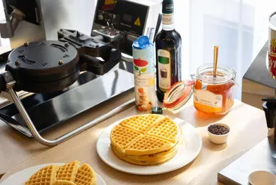 a counter with two waffles on a plate on a table at Hampton by Hilton Amsterdam Airport Schiphol in Hoofddorp