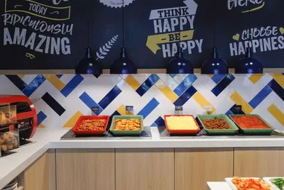 a buffet with bowls of food on a counter at Hampton by Hilton Amsterdam Airport Schiphol in Hoofddorp